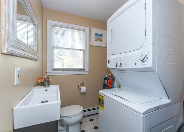 140 College Farm Rd, Waltham, MA 02451 - washroom featuring estacked washer and dryer, healthy amount of natural light, a baseboard heating unit, and baseboards
