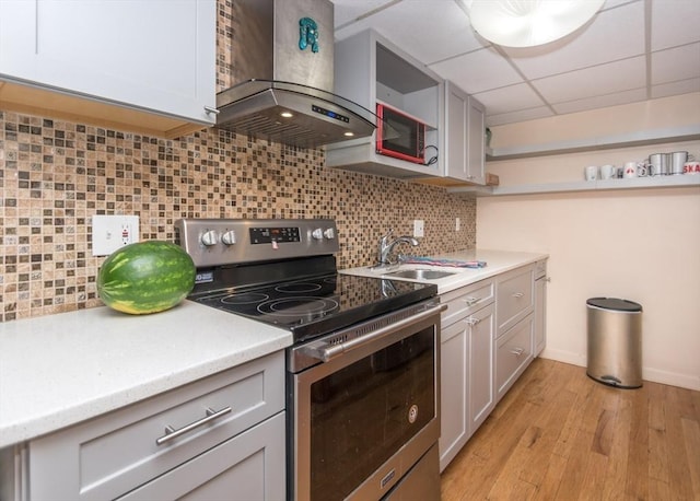 140 College Farm Rd, Waltham, MA 02451 - kitchen featuring stainless steel electric range, island range hood, a sink, light countertops, and light wood-style floors