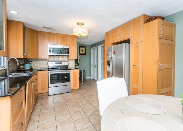 140 College Farm Rd, Waltham, MA 02451 - kitchen with appliances with stainless steel finishes, a sink, backsplash, light tile patterned flooring, and dark stone counters