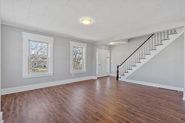 foyer featuring stairway, dark wood-style floors, baseboards, and ornamental molding