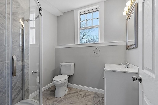 bathroom featuring toilet, a shower stall, vanity, and baseboards