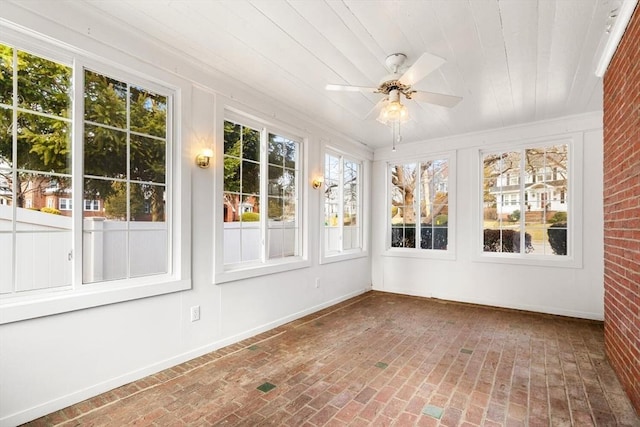 unfurnished sunroom with ceiling fan