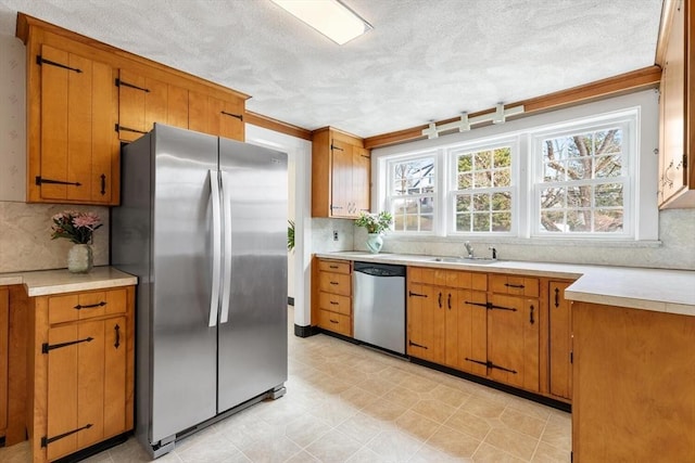 kitchen with a healthy amount of sunlight, stainless steel appliances, light countertops, and a sink