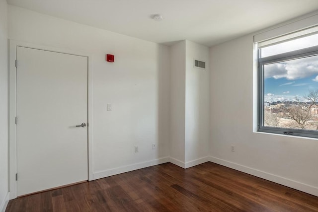 empty room with dark hardwood / wood-style flooring