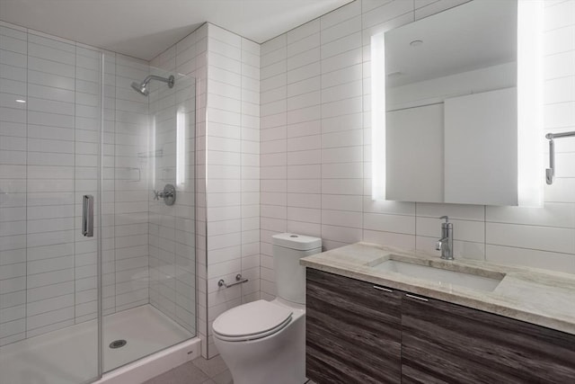 bathroom with tile walls, an enclosed shower, vanity, and toilet