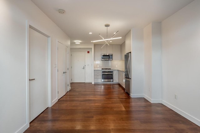 kitchen with stainless steel appliances, tasteful backsplash, dark wood-type flooring, and white cabinetry