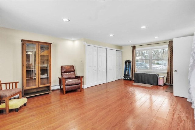 living area featuring wood-type flooring, radiator heating unit, and baseboard heating