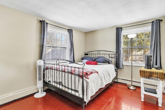 bedroom featuring baseboard heating and wood-type flooring