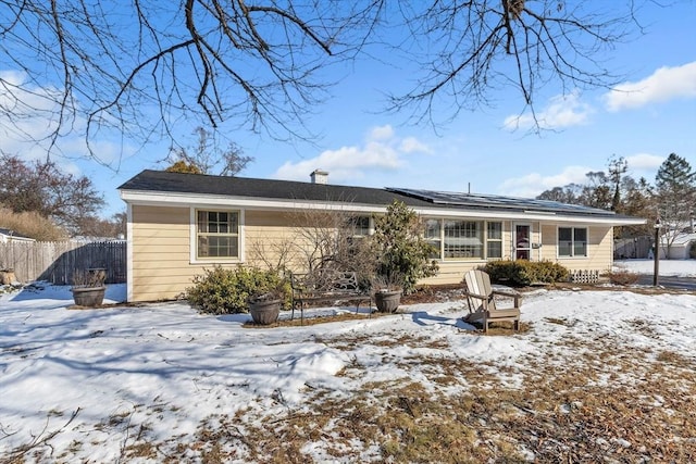 snow covered house featuring solar panels