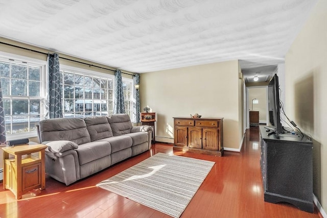 living room with dark wood-type flooring and a baseboard radiator