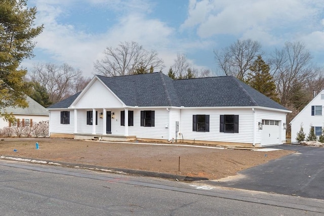 view of front of house featuring aphalt driveway, a garage, and roof with shingles