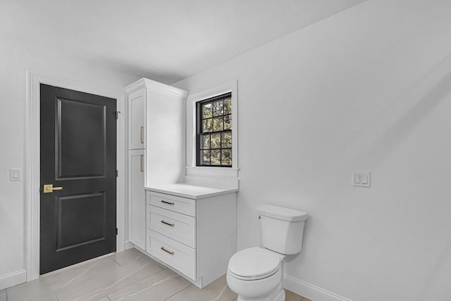 bathroom with toilet and baseboards