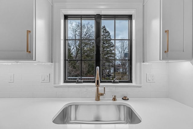 details featuring decorative backsplash, light countertops, and a sink