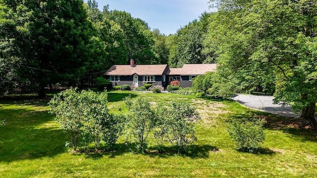 10 Corcoran Dr, Tyngsborough, MA 01879 - rear view of property featuring a chimney, a forest view, and a yard