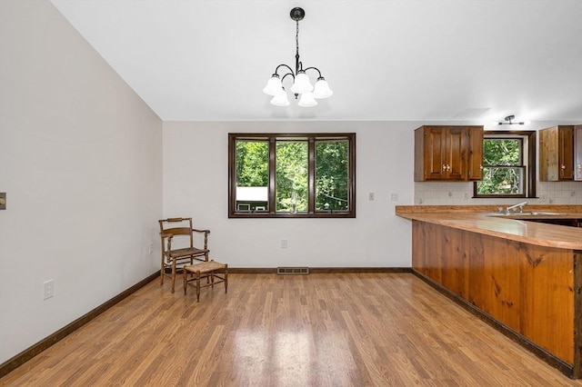 10 Corcoran Dr, Tyngsborough, MA 01879 - kitchen with light wood-style flooring, light countertops, plenty of natural light, and a chandelier