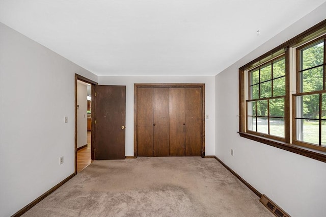10 Corcoran Dr, Tyngsborough, MA 01879 - unfurnished bedroom featuring baseboards, light carpet, and a closet