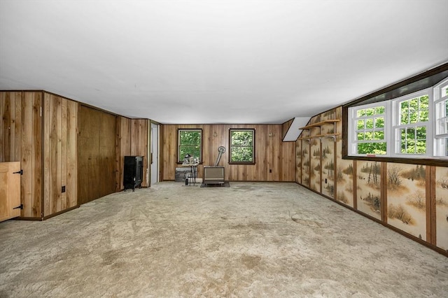 10 Corcoran Dr, Tyngsborough, MA 01879 - unfurnished living room with plenty of natural light, wooden walls, a wood stove, and carpet floors