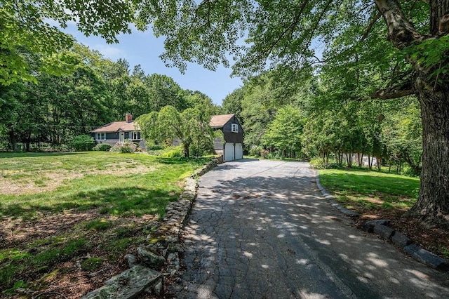 10 Corcoran Dr, Tyngsborough, MA 01879 - surrounding community featuring a garage, a lawn, and a forest view