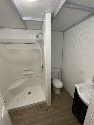 bathroom with a shower, vanity, wood-type flooring, and toilet