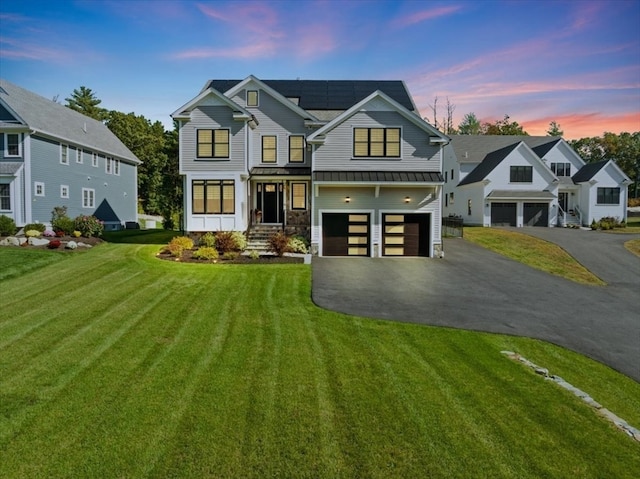 view of front of home featuring a garage and a lawn