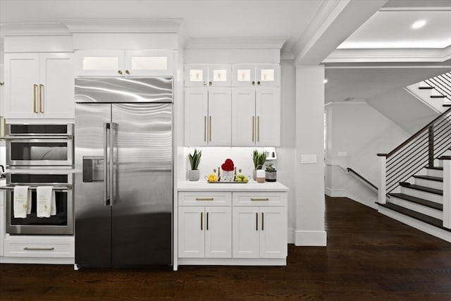 kitchen featuring ornamental molding, white cabinets, stainless steel appliances, and dark hardwood / wood-style floors