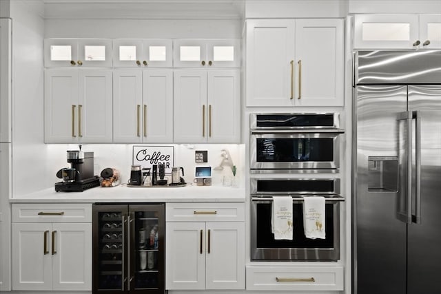 kitchen featuring wine cooler, appliances with stainless steel finishes, and white cabinetry