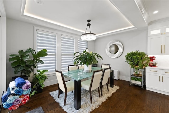 dining space with a tray ceiling and dark wood-type flooring