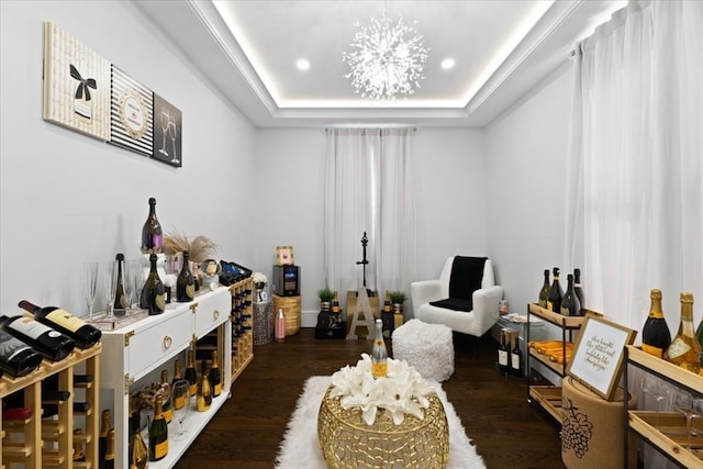 wine cellar featuring dark wood-type flooring, a tray ceiling, and a chandelier