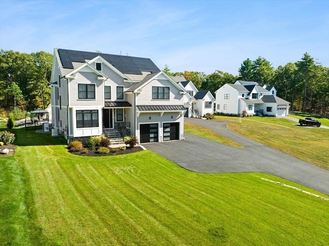 view of front of home with a front lawn, central AC unit, and a garage