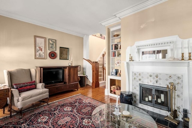 31 Mead St, Boston, MA 02129 - living area with hardwood / wood-style flooring, stairs, ornamental molding, built in shelves, and a tiled fireplace
