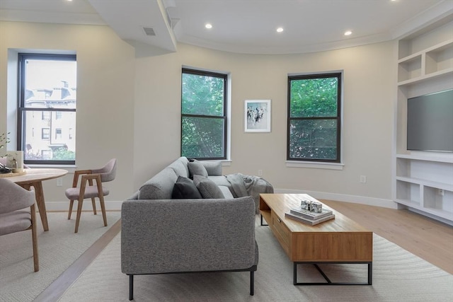 living room featuring built in shelves, recessed lighting, light wood-style floors, and baseboards