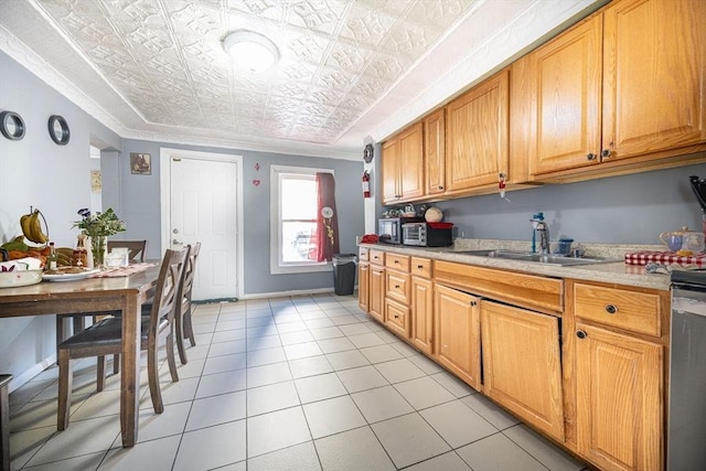 kitchen featuring ornamental molding, a sink, an ornate ceiling, light countertops, and light tile patterned floors