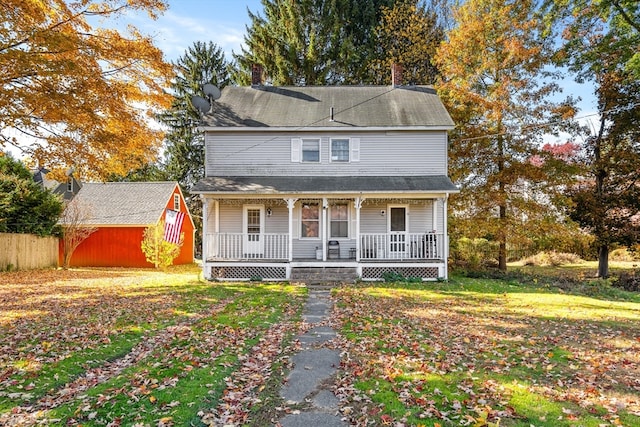 view of front of home with a porch and a shed