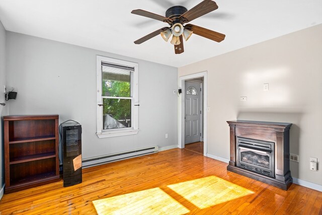 living room with wood-type flooring, baseboard heating, and ceiling fan