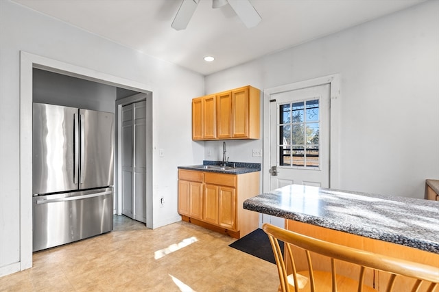 kitchen featuring ceiling fan, sink, and stainless steel refrigerator