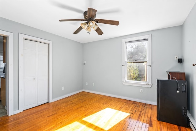 unfurnished bedroom with ceiling fan, a closet, and hardwood / wood-style flooring