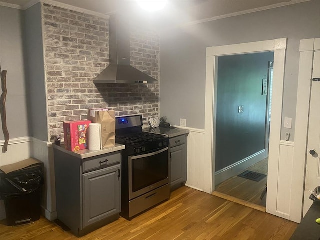 3 Moraine St, Andover, MA 01810 - kitchen with stainless steel gas range oven, island range hood, crown molding, gray cabinets, and light wood-style flooring