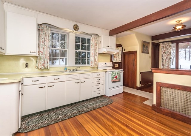 kitchen with light countertops, under cabinet range hood, white range with electric cooktop, a sink, and beam ceiling