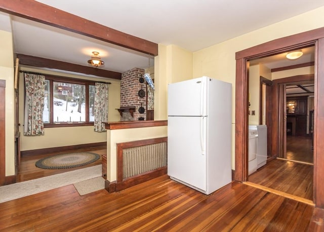 kitchen featuring beam ceiling, freestanding refrigerator, wood finished floors, washer / dryer, and baseboards