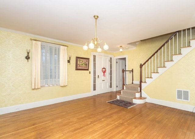 foyer entrance featuring crown molding, stairs, baseboards, hardwood / wood-style flooring, and visible vents