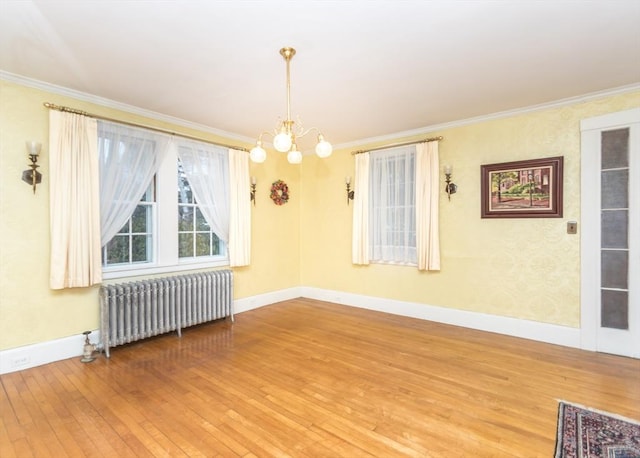 unfurnished room with ornamental molding, radiator heating unit, an inviting chandelier, and wood-type flooring