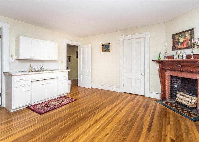 interior space with baseboards, a fireplace, and light wood-style flooring