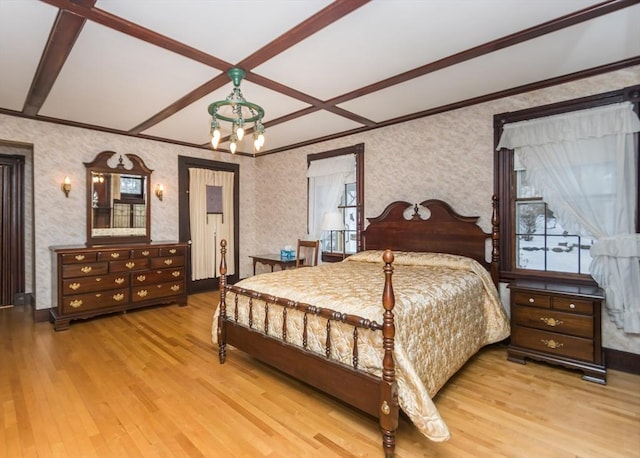 bedroom with ornamental molding, wood finished floors, a chandelier, and wallpapered walls