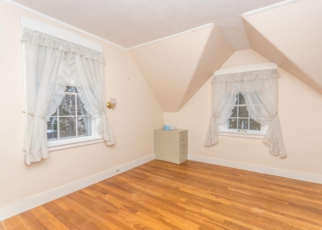 bonus room with baseboards, lofted ceiling, and wood finished floors
