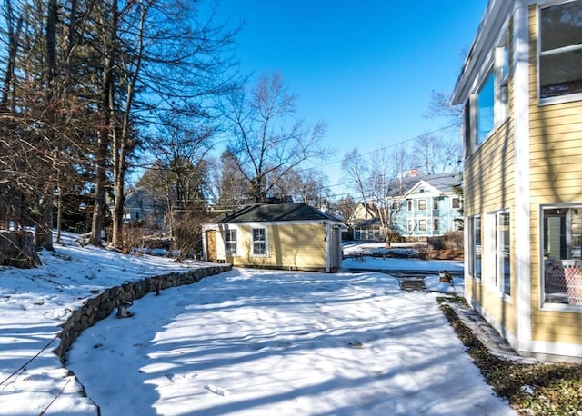 snowy yard with a residential view and an outbuilding