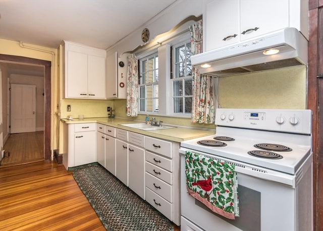 kitchen with light countertops, a sink, white electric stove, white cabinetry, and under cabinet range hood