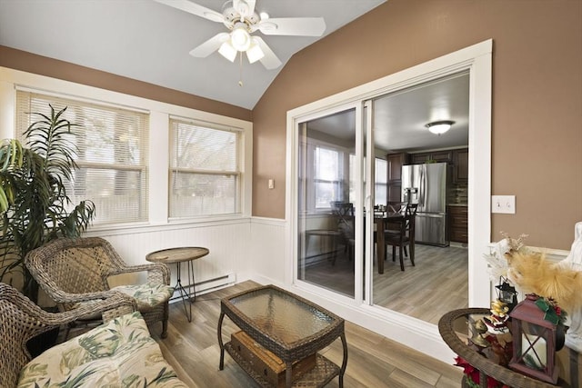 interior space featuring vaulted ceiling, ceiling fan, and a baseboard heating unit