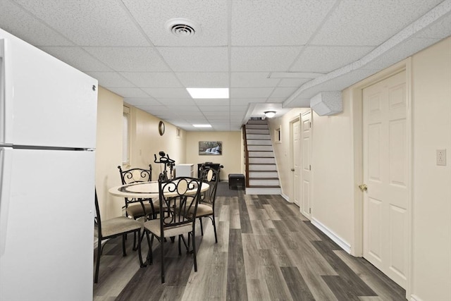 dining room with a paneled ceiling and dark wood-type flooring