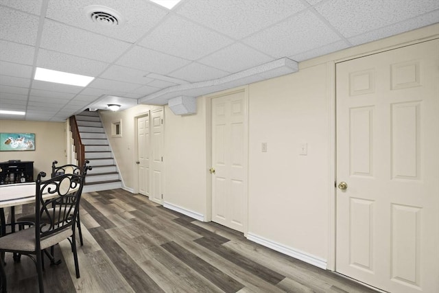 dining area with a paneled ceiling and dark wood-type flooring