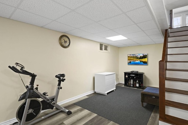 workout room with hardwood / wood-style floors and a paneled ceiling